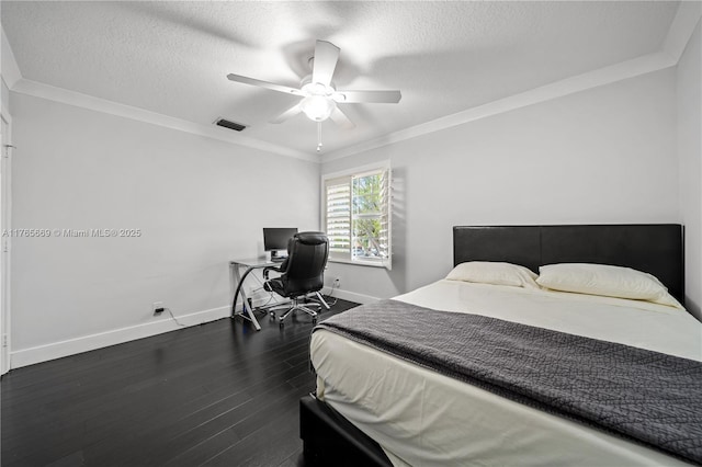 bedroom with visible vents, crown molding, dark wood-type flooring, baseboards, and a textured ceiling
