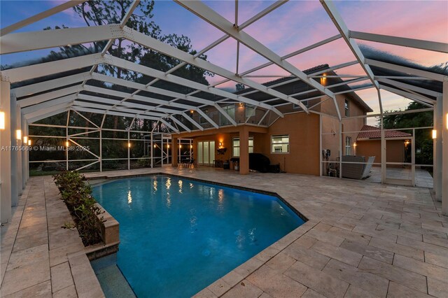 outdoor pool with a lanai and a patio area
