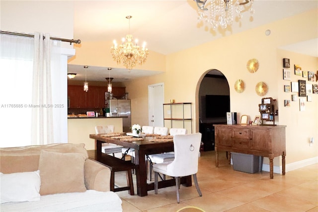 dining space with arched walkways, light tile patterned floors, and a chandelier