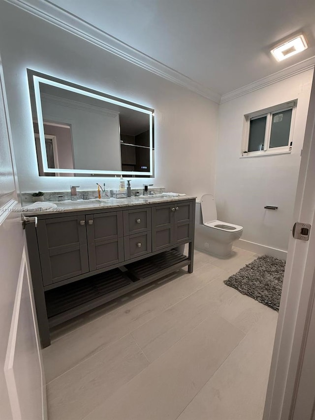full bath with toilet, double vanity, a sink, and crown molding