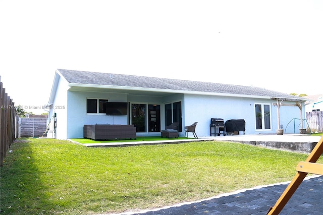 rear view of property featuring stucco siding, fence, french doors, and a yard