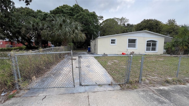 607 N 19th St, Fort Pierce, FL 34950 - view of front of house with a fenced front yard, a front yard, driveway, and stucco siding