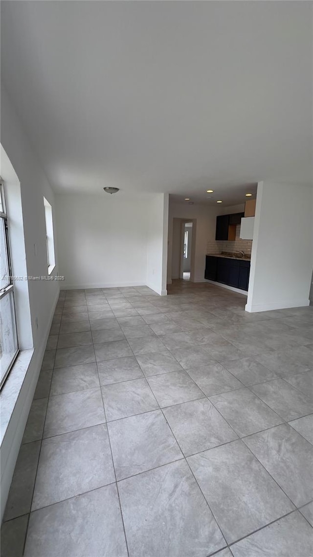 607 N 19th St, Fort Pierce, FL 34950 - unfurnished living room with light tile patterned flooring and baseboards
