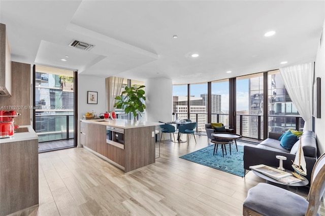 kitchen with visible vents, light countertops, floor to ceiling windows, a city view, and modern cabinets