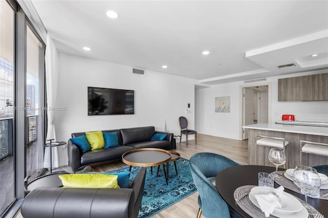 living area featuring visible vents, recessed lighting, and light wood-style floors