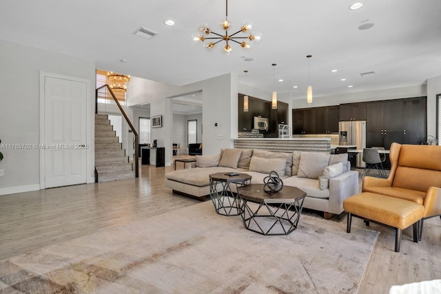 living room featuring recessed lighting, a notable chandelier, stairway, and visible vents