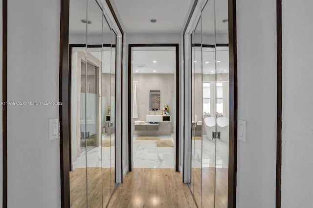 hall with marble finish floor and recessed lighting