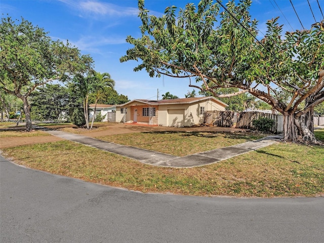 4401 Johnson St, Hollywood, FL 33021 - view of front facade featuring a front lawn, fence, roof mounted solar panels, and stucco siding