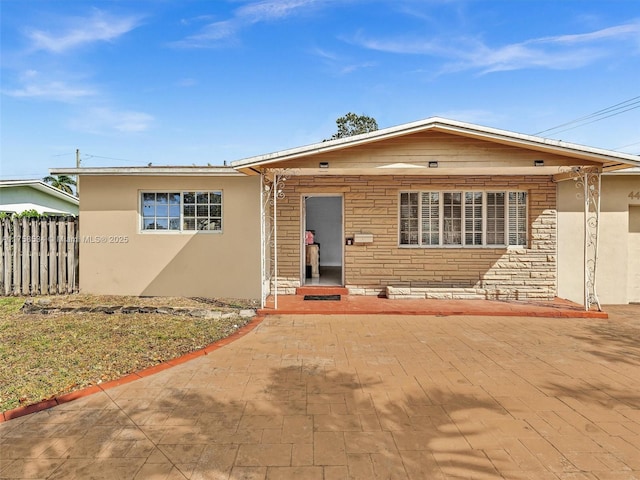 4401 Johnson St, Hollywood, FL 33021 - view of front of property with stone siding, stucco siding, and fence