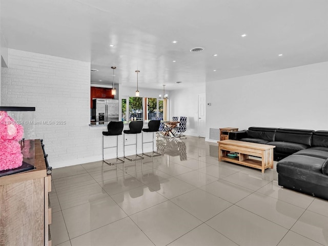 4401 Johnson St, Hollywood, FL 33021 - living area featuring light tile patterned floors, visible vents, recessed lighting, and brick wall