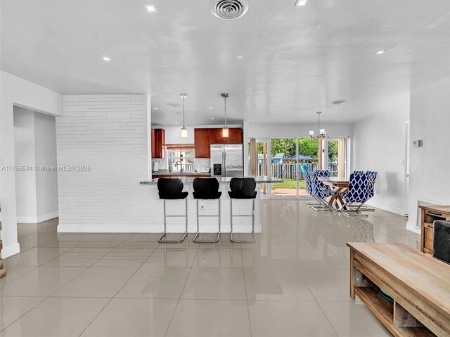 4401 Johnson St, Hollywood, FL 33021 - kitchen with visible vents, stainless steel refrigerator with ice dispenser, a breakfast bar area, light countertops, and light tile patterned floors