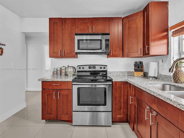 4401 Johnson St, Hollywood, FL 33021 - kitchen with a sink, light stone counters, appliances with stainless steel finishes, light tile patterned flooring, and baseboards