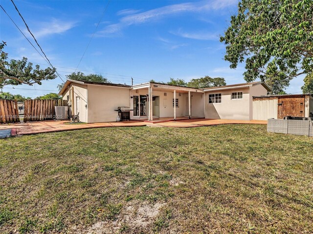 4401 Johnson St, Hollywood, FL 33021 - rear view of house with stucco siding, a lawn, and fence