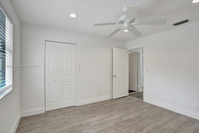 unfurnished bedroom with baseboards, visible vents, and wood finished floors