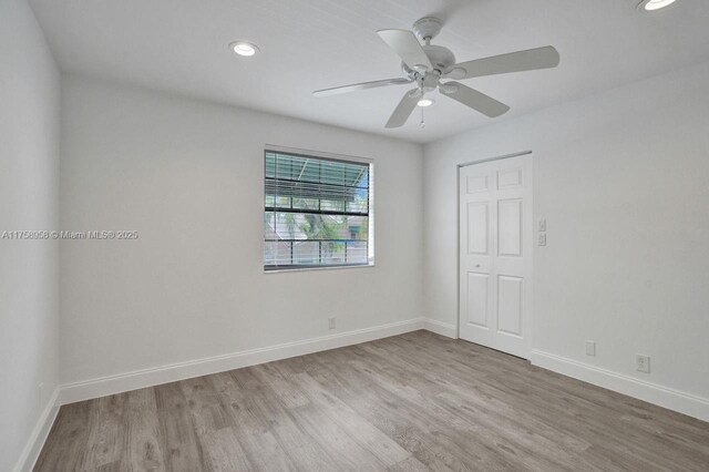 empty room featuring baseboards, wood finished floors, recessed lighting, and a ceiling fan