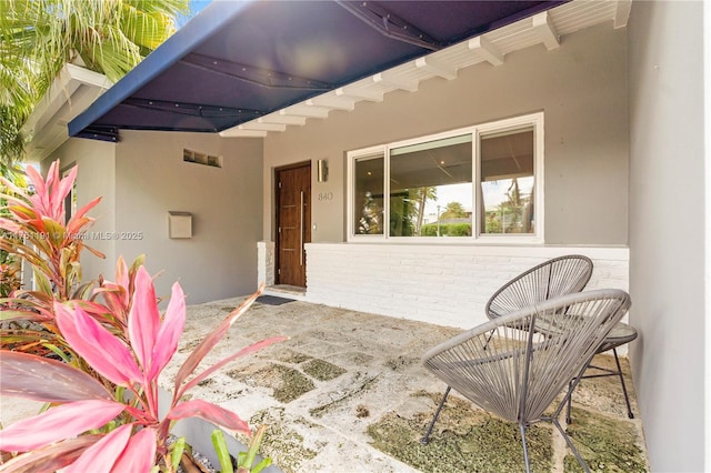 property entrance with stucco siding and brick siding