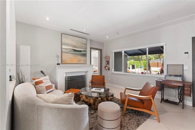 living room featuring baseboards, a fireplace, visible vents, and recessed lighting