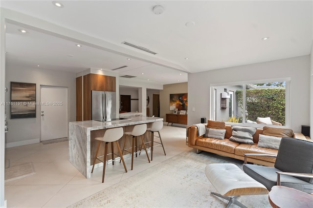 living area with light tile patterned flooring, baseboards, visible vents, and recessed lighting