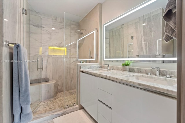 full bath with a shower stall, double vanity, and a sink