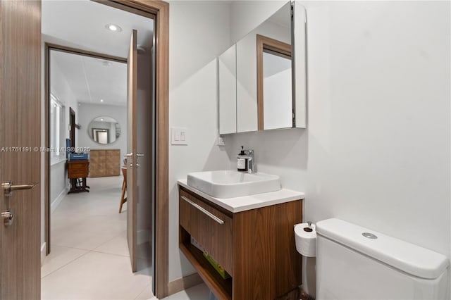 half bathroom featuring tile patterned floors, toilet, and vanity