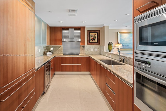 kitchen featuring wall chimney range hood, a sink, modern cabinets, and appliances with stainless steel finishes