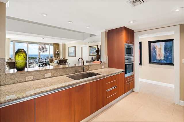 kitchen with visible vents, modern cabinets, brown cabinets, stainless steel appliances, and a sink