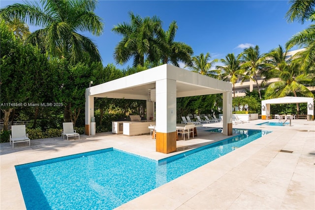 community pool featuring area for grilling and a patio area