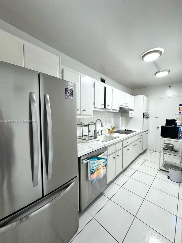 100 Lincoln Rd Unit 1231, Miami Beach, FL 33139 - kitchen featuring appliances with stainless steel finishes, light countertops, white cabinetry, a sink, and light tile patterned flooring