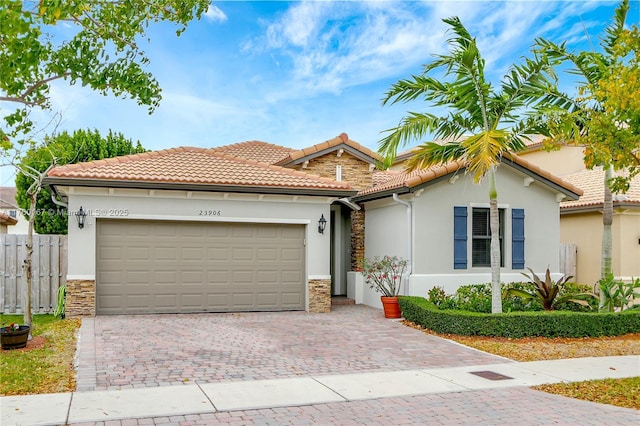 23906 SW 116th Ct, Homestead, FL 33032 - mediterranean / spanish house with stone siding, stucco siding, a garage, and a tiled roof