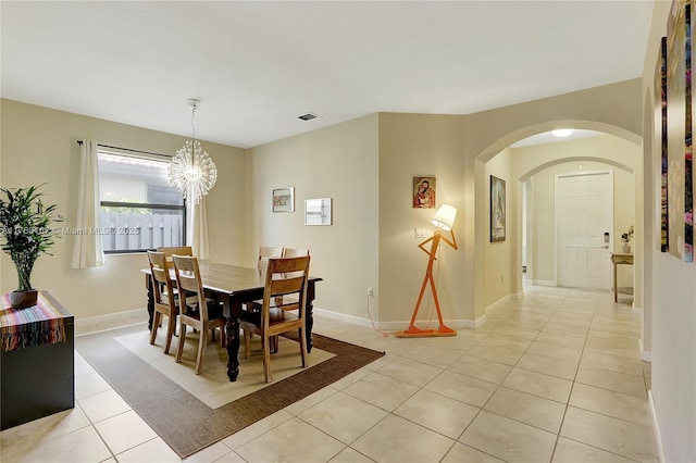 dining space with visible vents, baseboards, an inviting chandelier, light tile patterned flooring, and arched walkways