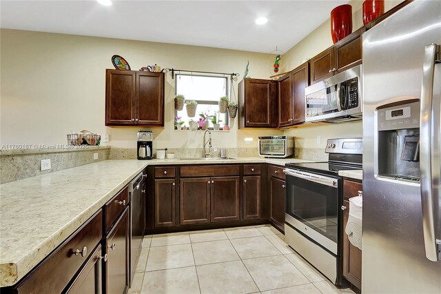 23906 SW 116th Ct, Homestead, FL 33032 - kitchen with stainless steel appliances, a sink, light tile patterned floors, light countertops, and recessed lighting