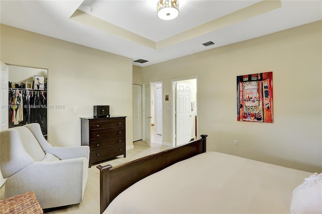 bedroom featuring a tray ceiling and visible vents