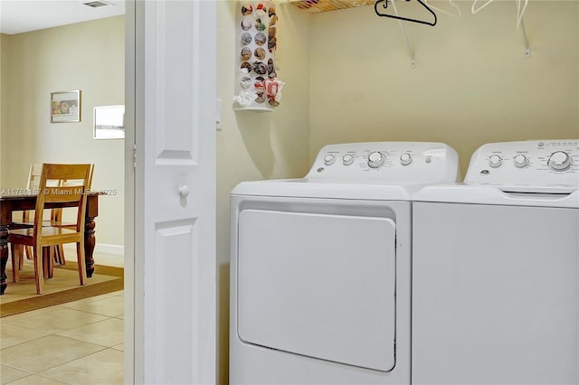 washroom with laundry area, light tile patterned flooring, visible vents, and washing machine and clothes dryer