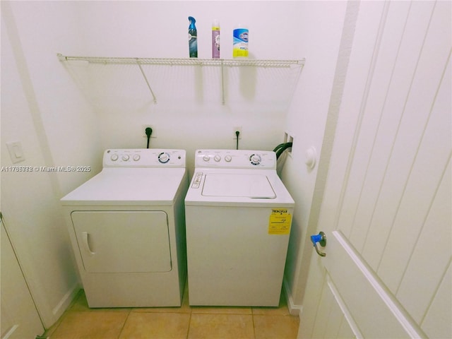 laundry room featuring light tile patterned floors, laundry area, baseboards, and separate washer and dryer