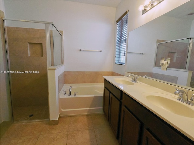 bathroom with tile patterned flooring, a shower stall, a garden tub, and a sink