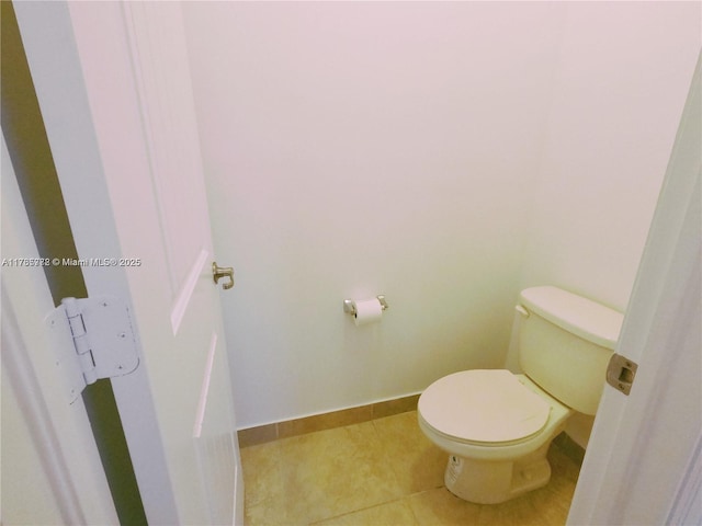 bathroom featuring tile patterned flooring, toilet, and baseboards