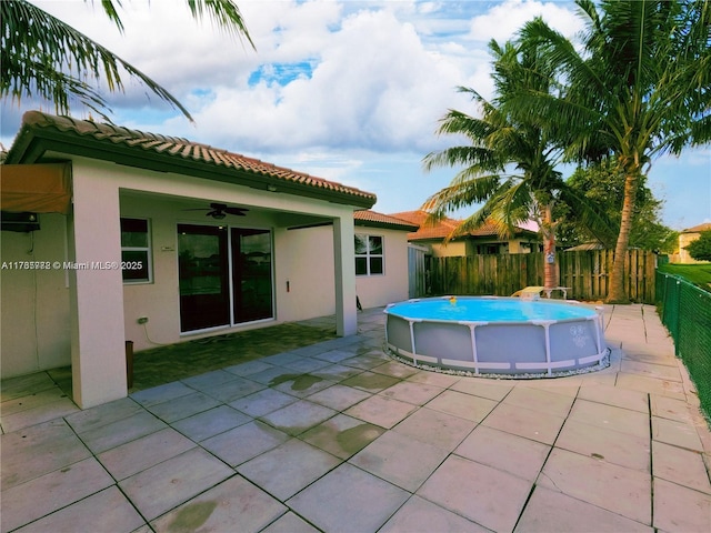 view of pool with a ceiling fan, a patio area, a fenced in pool, and fence