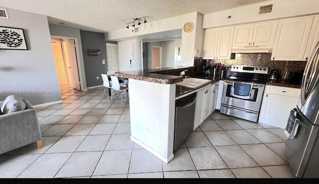 19555 E Country Club Dr Unit 8507, Aventura, FL 33180 - kitchen with a peninsula, a sink, stainless steel appliances, under cabinet range hood, and dark countertops