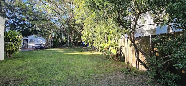 view of yard with a storage unit, a fenced backyard, and an outdoor structure