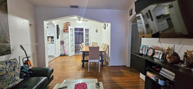 living area featuring visible vents, a ceiling fan, and wood finished floors