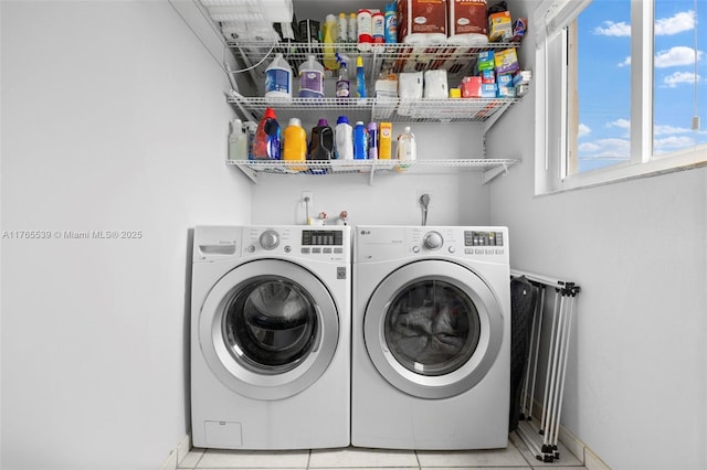 clothes washing area with separate washer and dryer, tile patterned flooring, baseboards, and laundry area