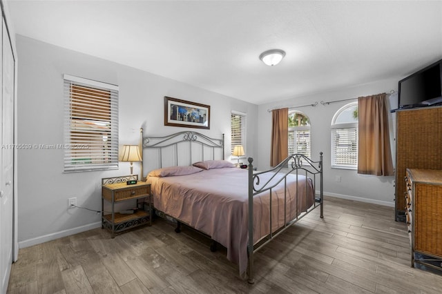 bedroom with baseboards and wood finished floors