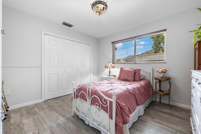 bedroom featuring a closet, baseboards, visible vents, and light wood-type flooring