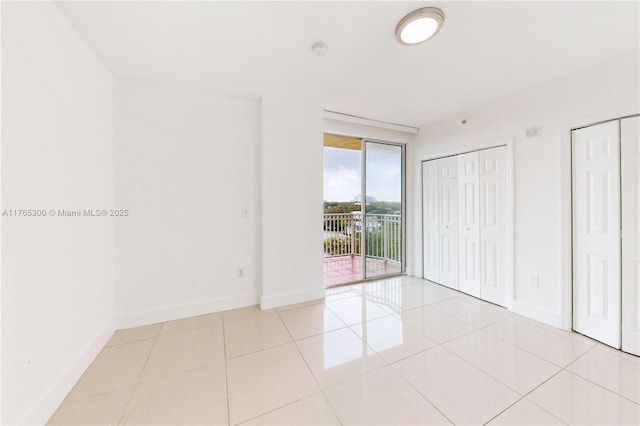 1650 Coral Way Unit Ph-9, Miami, FL 33145 - unfurnished bedroom featuring access to outside, multiple closets, baseboards, and tile patterned floors