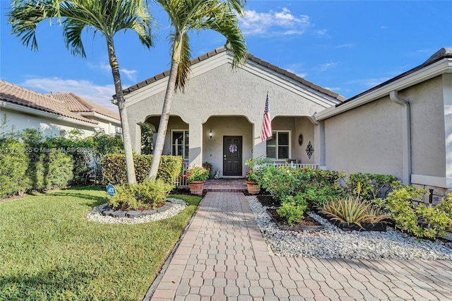 property entrance featuring stucco siding and a yard