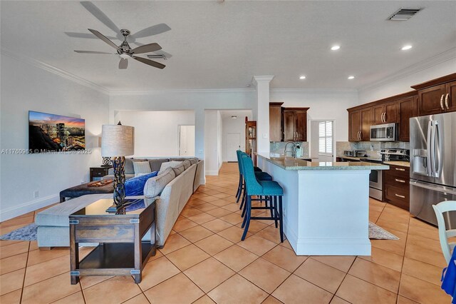 living area featuring a ceiling fan, baseboards, and ornamental molding