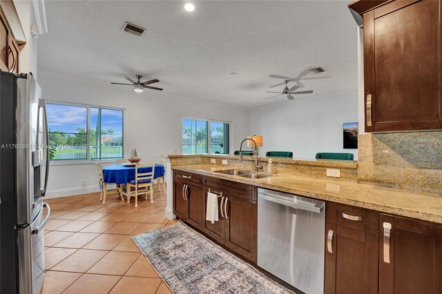 kitchen with tasteful backsplash, light stone countertops, appliances with stainless steel finishes, and ornamental molding