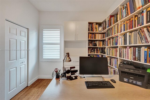 office featuring wood finished floors, a ceiling fan, and baseboards