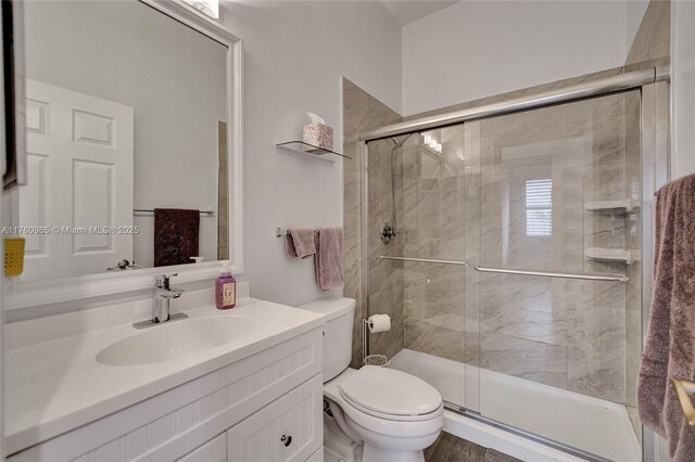 full bath featuring vanity, a shower stall, and toilet