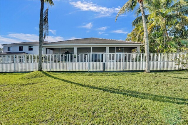 view of home's exterior with a sunroom, a fenced backyard, ceiling fan, and a lawn